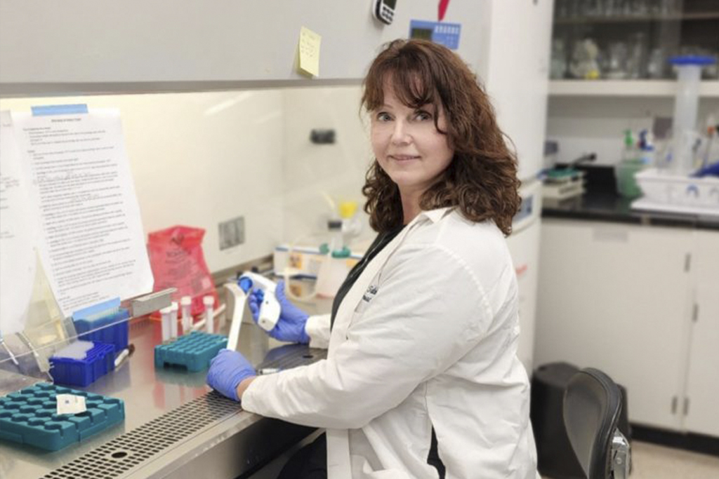 Dr. Susanne Talcott standing in her lab while holding lab equipment