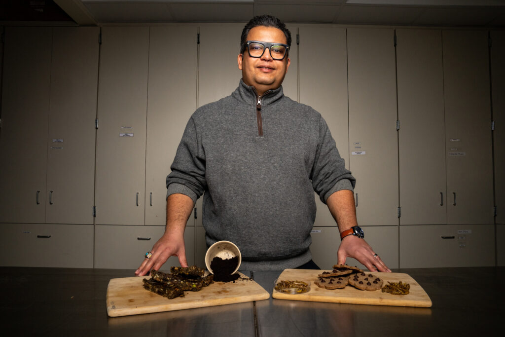 Ovissipour stands behind a countertop with cutting boards of his new food items.