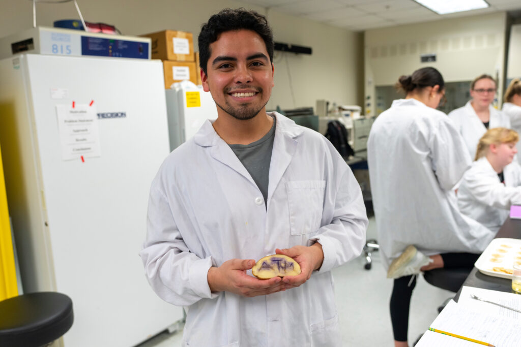 Student holding up his potato with 'A&M' engraved into it