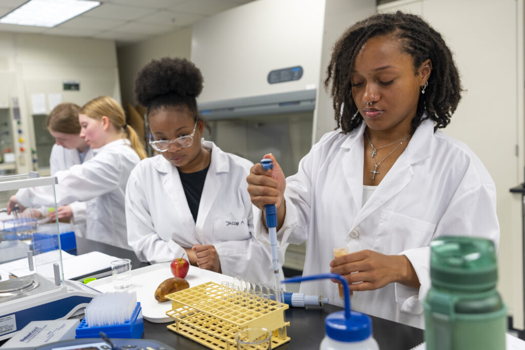 Students in lab utilizing a pipette