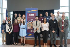 a group of students posing around a banner