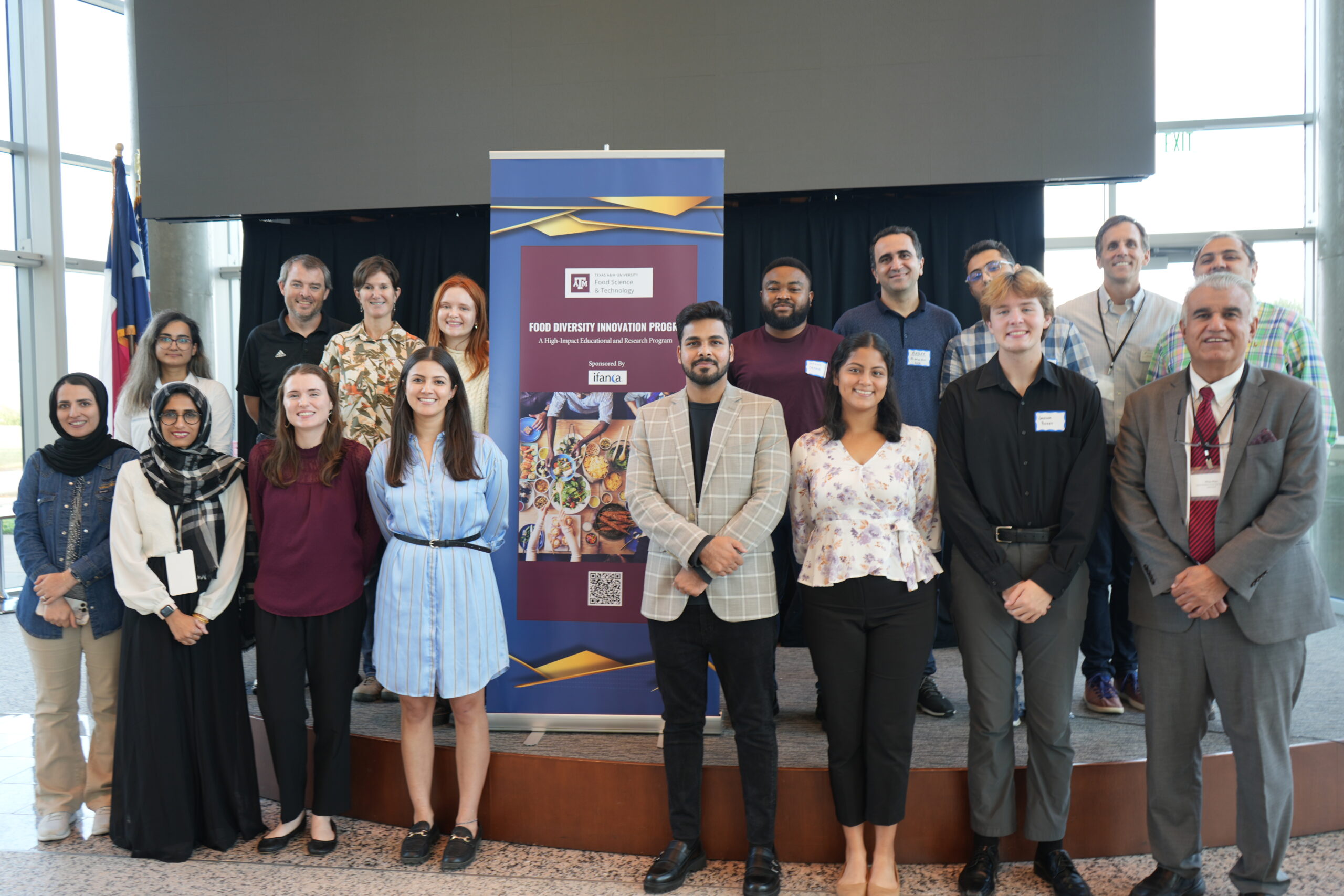 a group of students posing around a banner